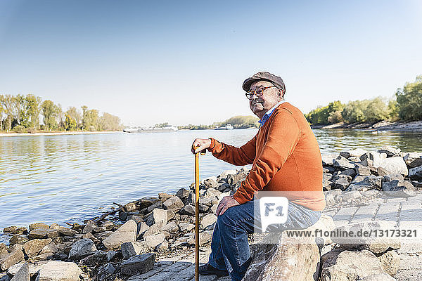Alter Mann am Fluss sitzend