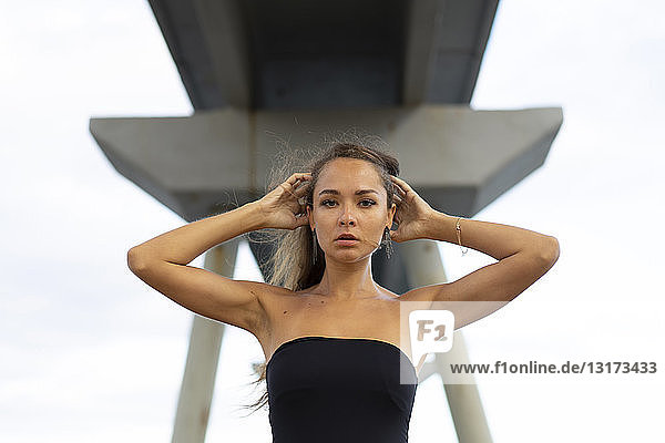 Portrait of beautiful young woman under a bridge