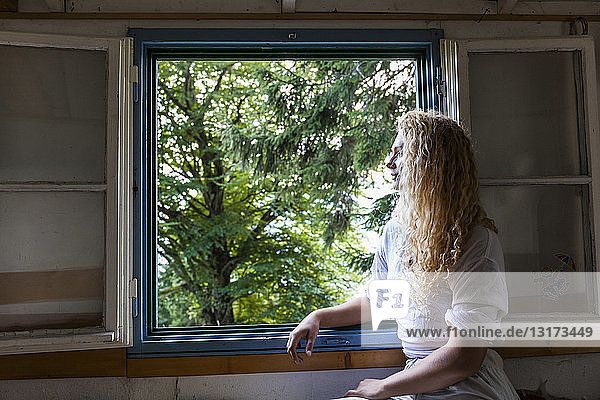 Junge Frau  die aus dem Fenster eines Wohnwagens schaut