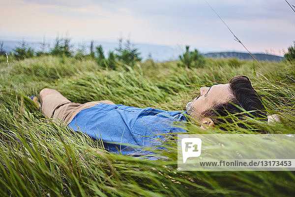 Relaxed man lying in grass