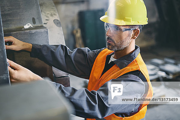 Mann trägt Arbeitsschutzkleidung bei der Arbeit in der Fabrik