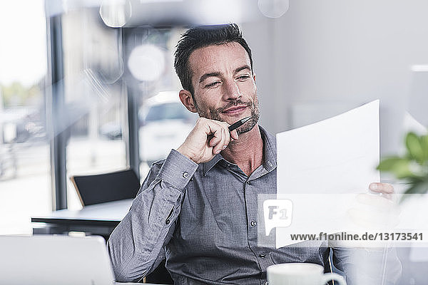 Businessman sitting in office  reading a letter