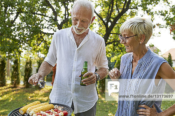 Älteres Ehepaar beim Grillen im Garten