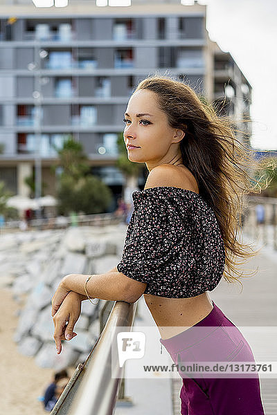 Portrait of beautiful young woman standing on promenade