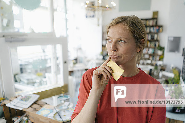 Junge Frau mit Karte in einem Cafe beim Denken