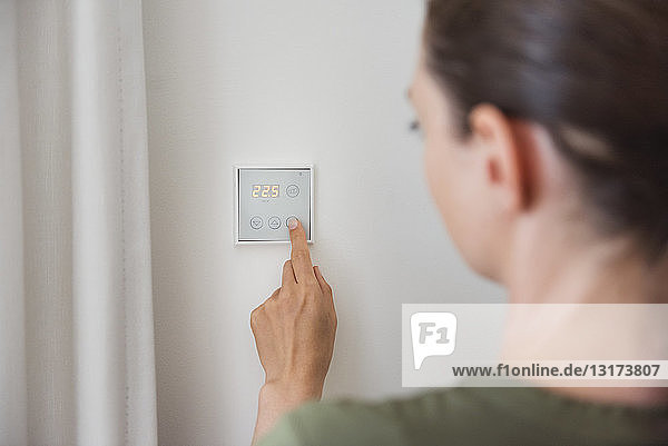 Frau benutzt Smart Home-Schalter an der Wand