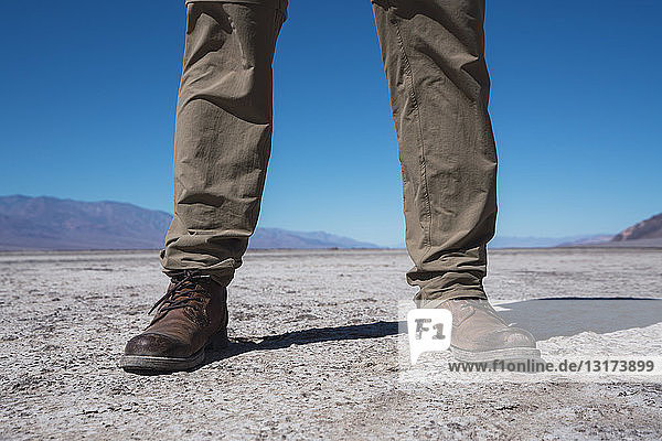 USA  California  Death Valley  man standing in desert  partial view