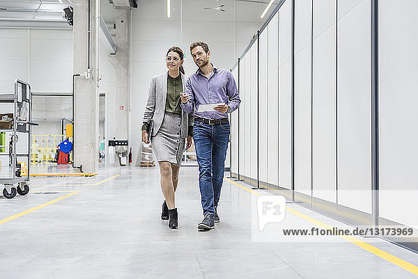 Businessman and woman walking in company  discussing new strategies