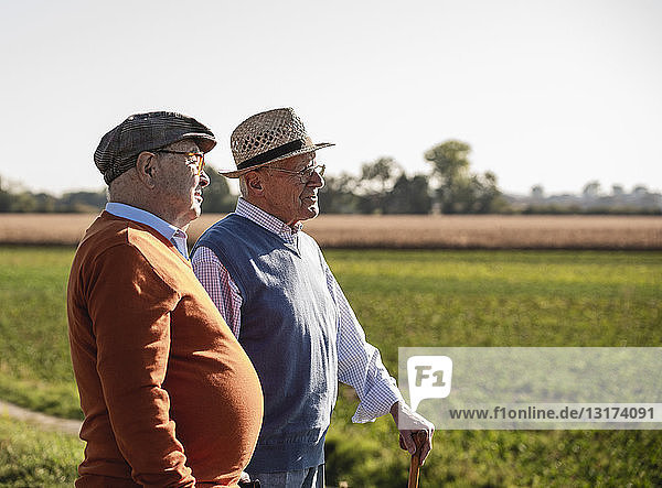 Two old friends standing in the fields  talking about old times