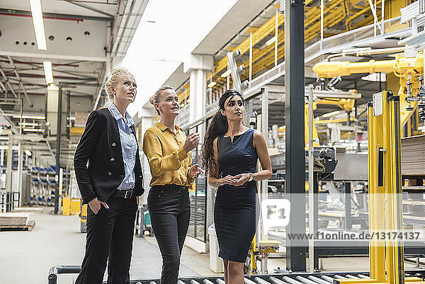 Three women talking in modern factory