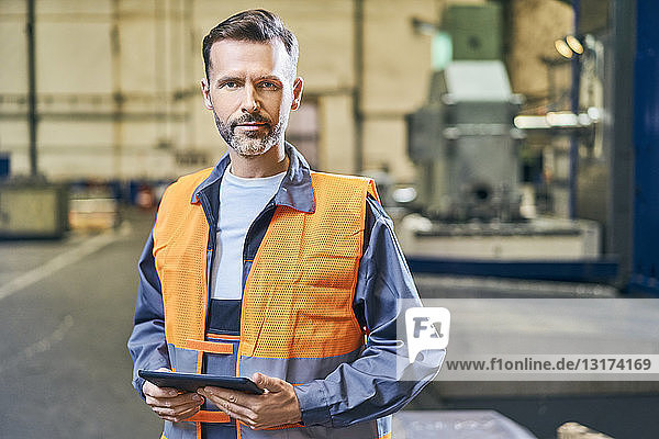 Porträt eines Mannes mit Tablette in der Fabrik
