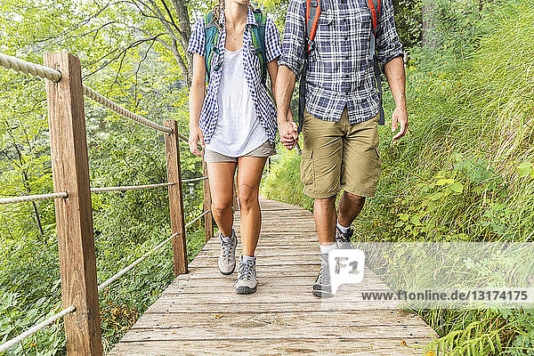 Italy  Massa  legs of young couple hiking and walking on a boardwalk in the Alpi Apuane