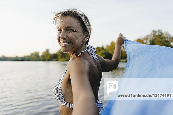 Portrait of happy woman at a lake