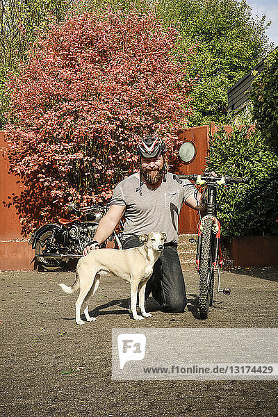 Porträt eines lächelnden Mannes mit Hund und Fahrrad