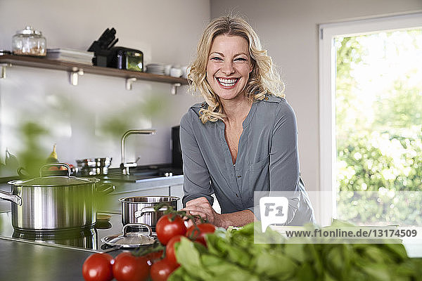 Porträt einer glücklichen Frau beim Kochen in der Küche