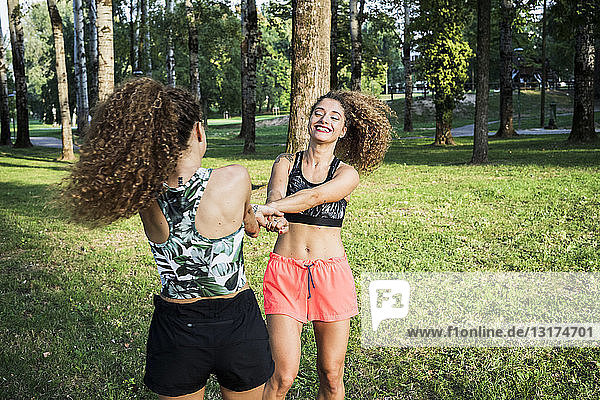 Zwillingsschwestern amüsieren sich gemeinsam in einem Park