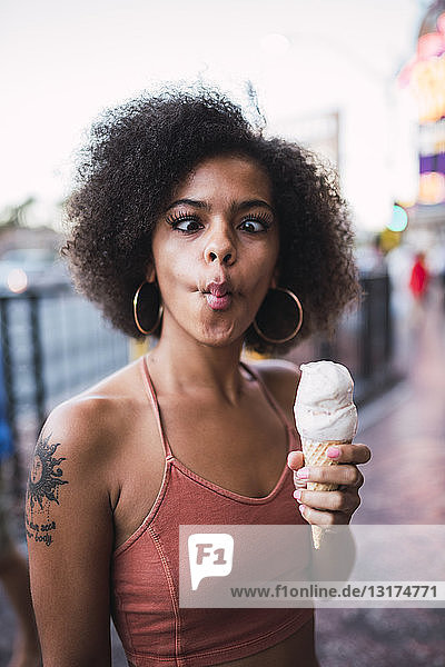 USA  Nevada  Las Vegas  Porträt einer jungen Frau  die eine Eistüte in der Hand hält und Grimassen schneidet