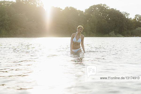 Portrait of happy woman wearing a bikini in a lake