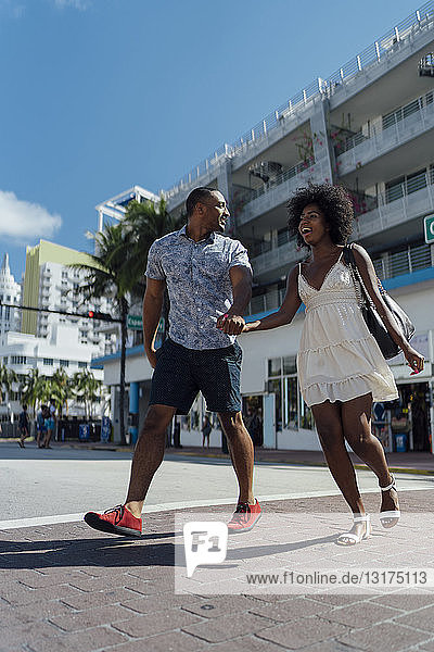 USA  Florida  Miami Beach  glückliches junges Paar beim Überqueren der Straße