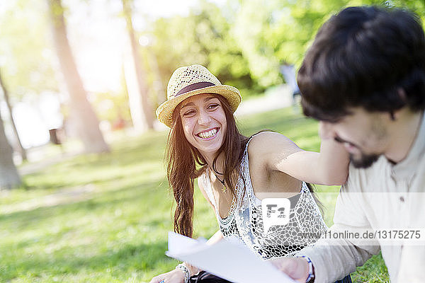 Portrait of laughing young woman having fun in a park with her fellow student