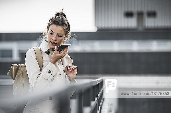 Junge Geschäftsfrau nutzt Smartphone in der Stadt