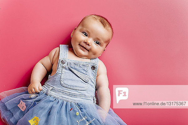 Porträt eines lächelnden Mädchens auf rosa Hintergrund
