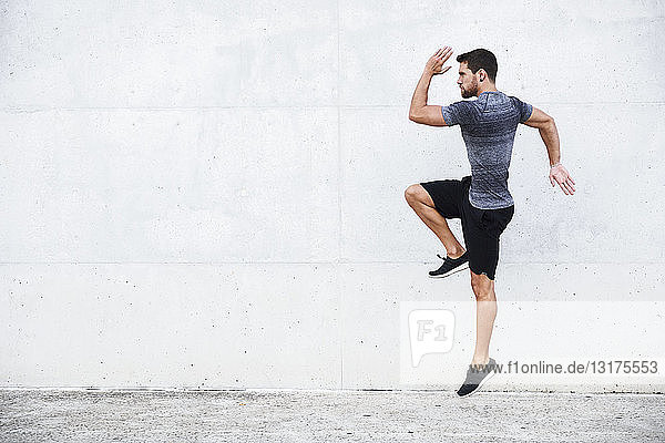 Athlete jumping in front of white wall