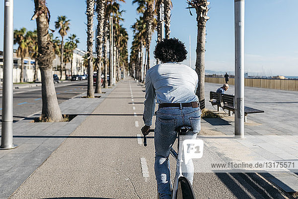 Mittelgroßer erwachsener Mann auf dem Fahrrad in der Stadt  in Strandnähe