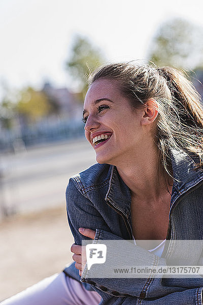 Porträt einer lachenden jungen Frau im Freien