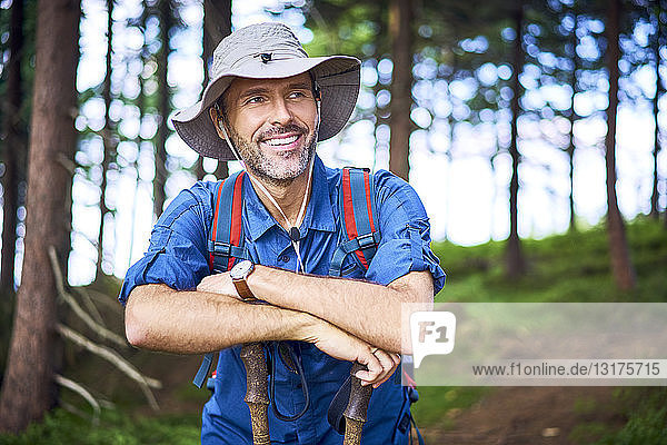 Smiling man having a break from hiking in the forest