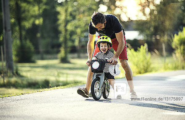 Vater unterrichtet kleinen Sohn beim Fahrradfahren