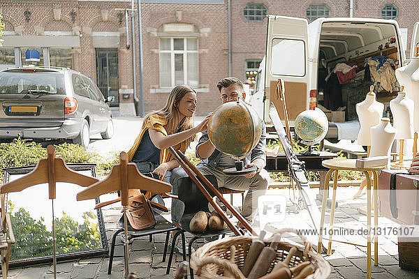 Belgien  Tongeren  junges Paar untersucht den Globus auf einem Antiquitäten-Flohmarkt