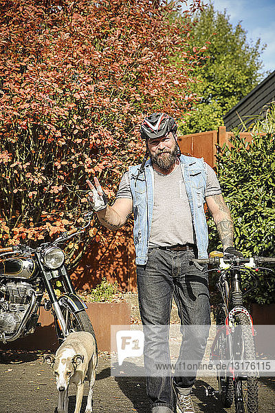 Porträt eines Mannes  der vom Motorrad aufs Fahrrad umsteigt