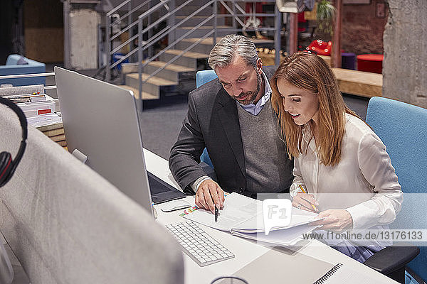 Businessman and woman working together in modern office