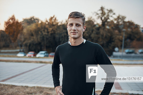 Portrait of confident sportive man outdoors in the evening