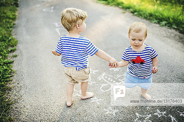 Kleinkind spielt mit seiner kleinen Schwester im Freien