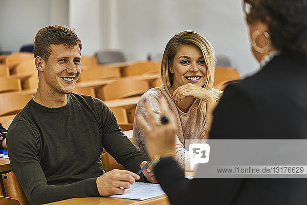 Lächelnde Studenten und Dozent im Auditorium der Universität