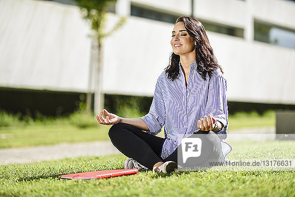 Portrait of smiling student doing yoga exercices on campus