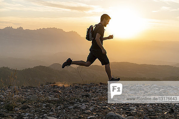 Spain  Barcelona  Natural Park of Sant Llorenc  man running in the mountains at sunset