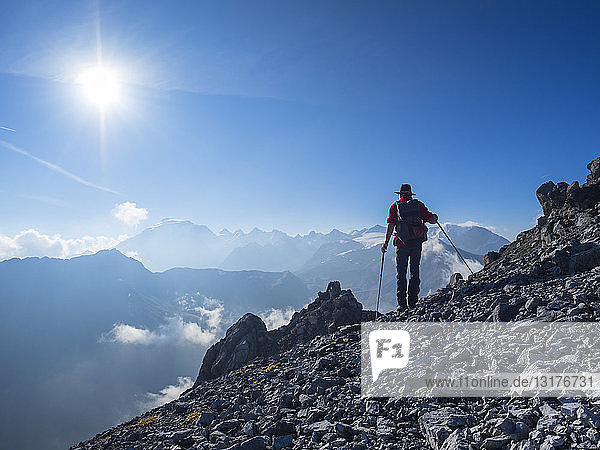Border region Italy Switzerland  senior man hiking in mountain landscape at Piz Umbrail