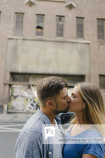 Affectionate young couple kissing in the city