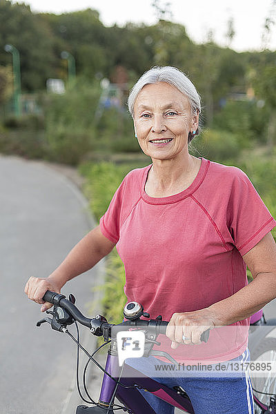 Porträt einer älteren Frau mit Fahrrad