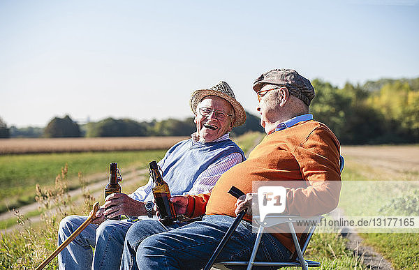 Two old friends sitting in the fields  drinking beer  talking about old times