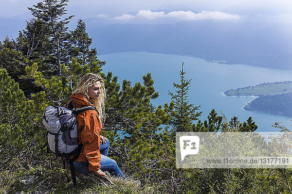 Young woman hiking in the Bavarian mountains,  looking at Lake Walchensee