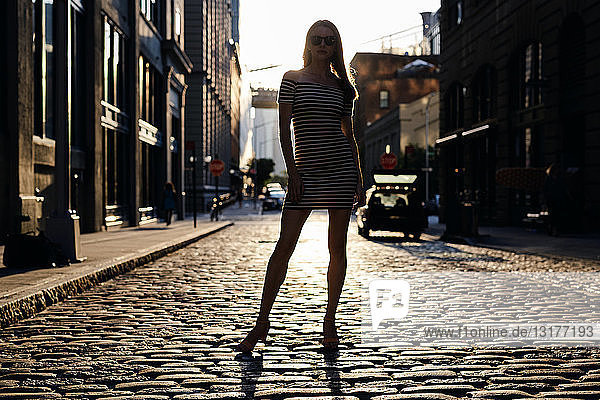 USA  New York  Brooklyn  Dumbo  Silhouette einer jungen Frau  die im Gegenlicht auf der Straße steht