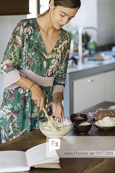 Young woman preparing cake dough