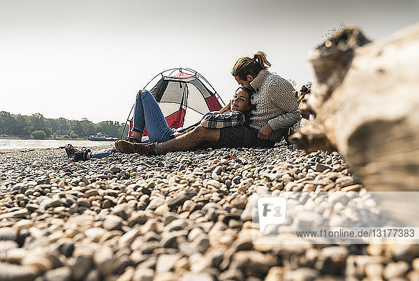 Glückliches junges Paar entspannt sich in einem Zelt am Flussufer