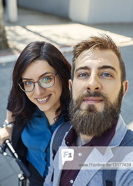 Selfie of happy business couple with scooter