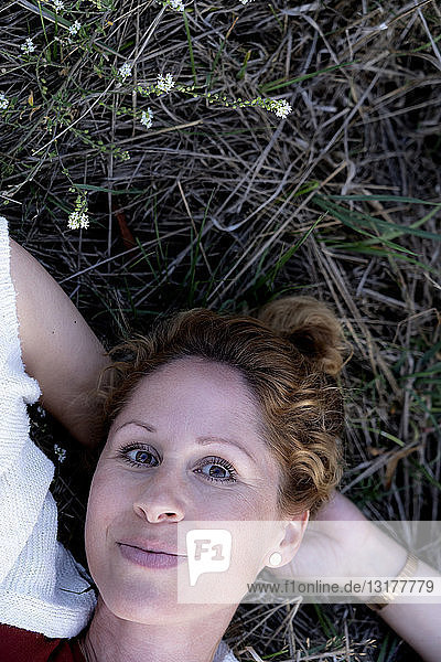 Portrait of smiling woman lying on the ground