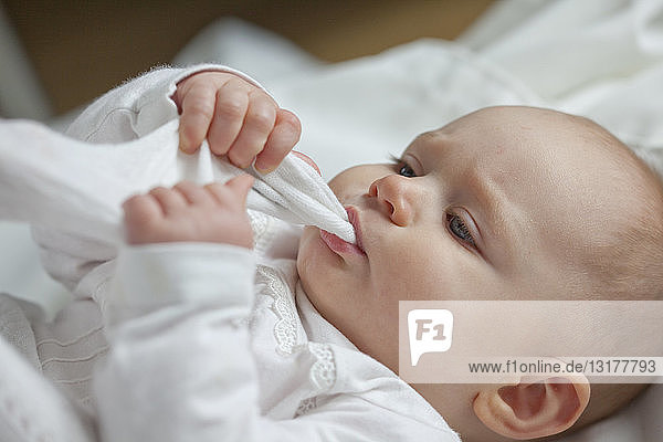 Baby girl sucking cloth